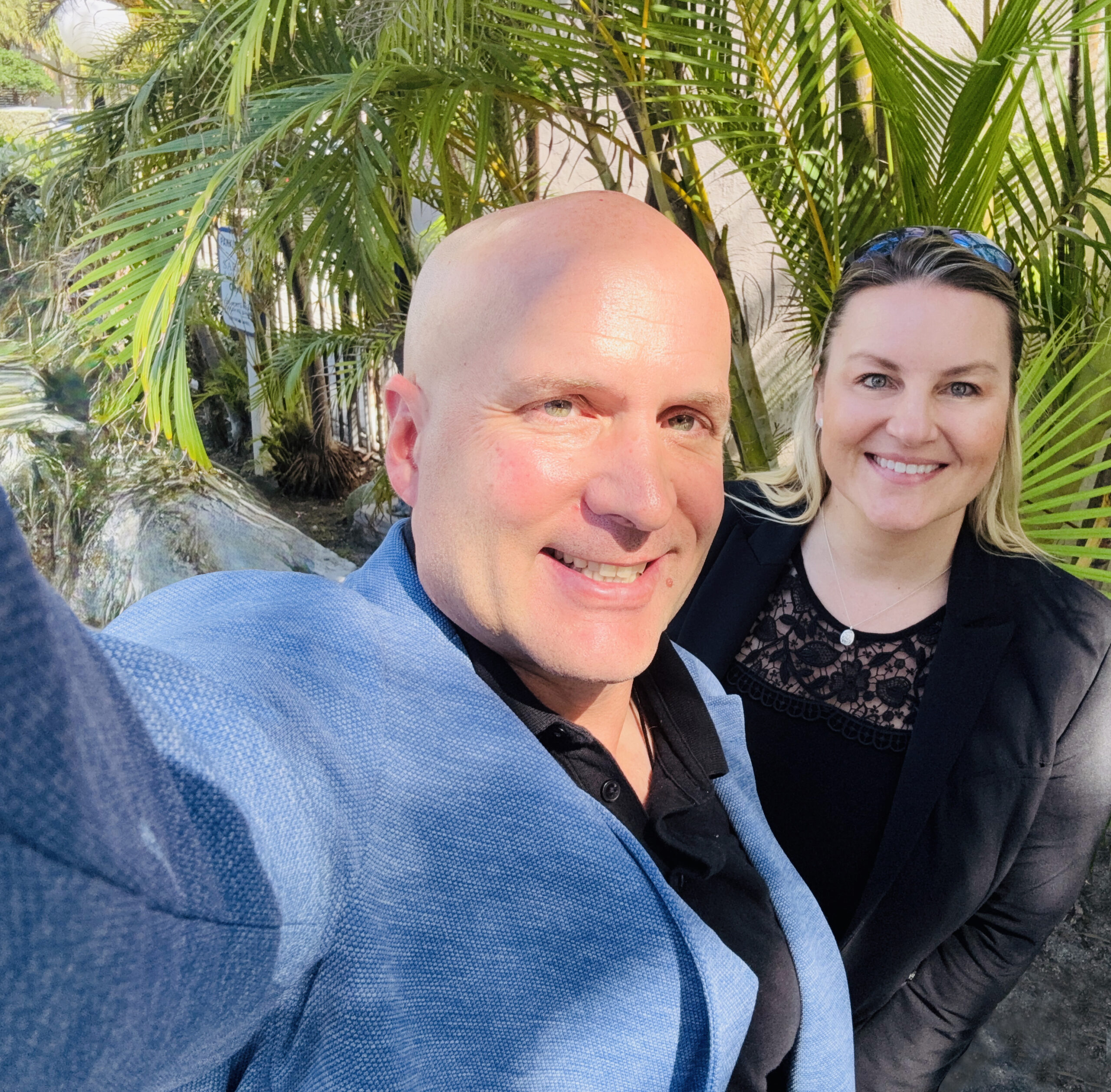 Two colleagues. One woman, one man, both smiling.